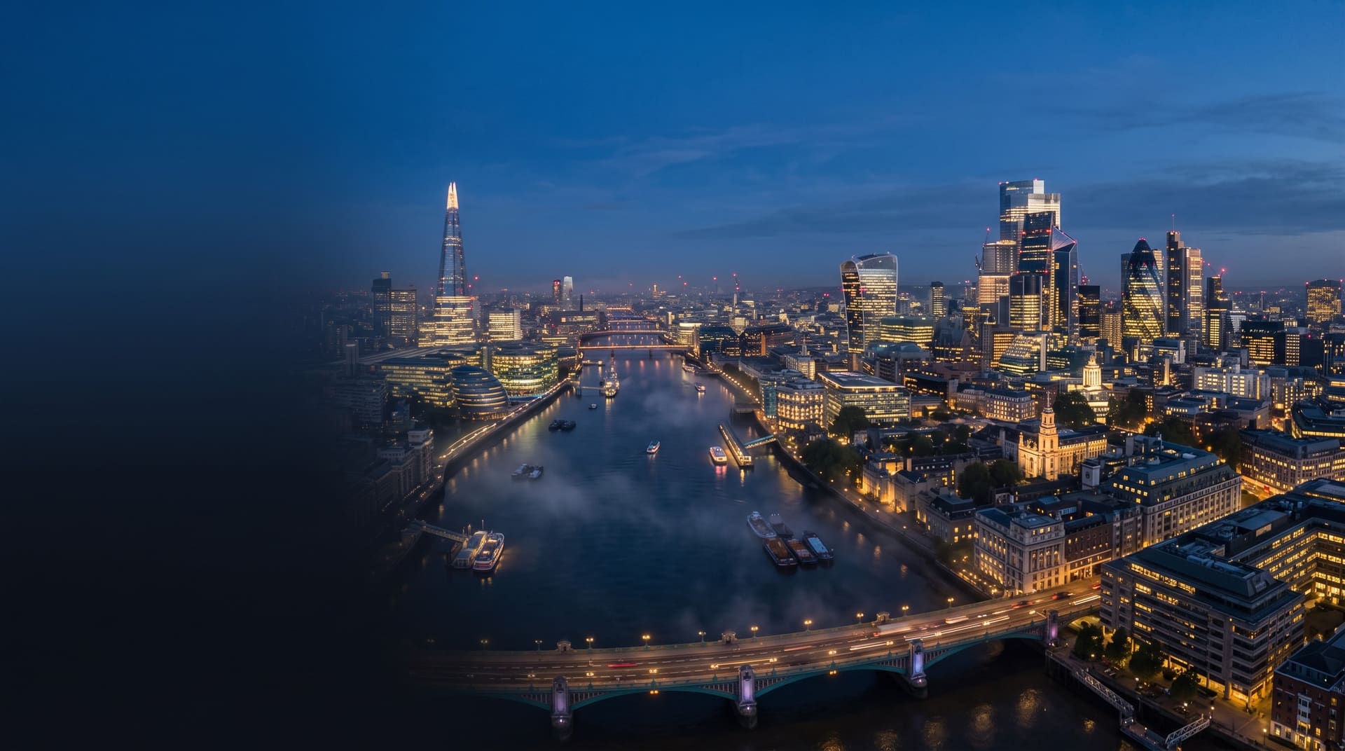 Aerial view of the London skyline at blue hour, with the City of London and the River Thames.
